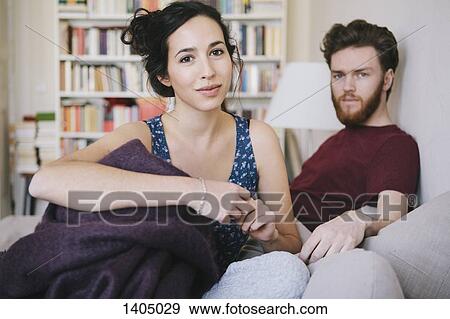 Stock Photo - Portrait of young woman with man relaxing in bed. Fotosearch