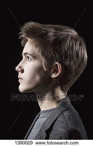 Stock Photo - Profile shot of teenage boy over black background. Fotosearch