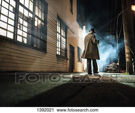 Rear view of man walking outside building at night View Large Photo Image Stock Image - Rear view of man walking outside building at night. Fotosearch