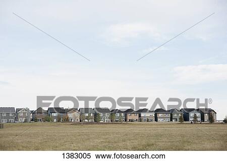 Row houses against cloudy sky View Large Photo Image Stock Photography - Row houses against cloudy sky. Fotosearch
