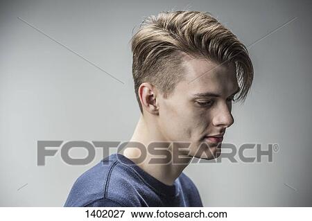 Stock Photo - Sad young man against gray background. Fotosearch