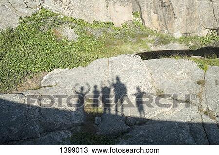 Stock Image - Shadow of friends on rock. Fotosearch