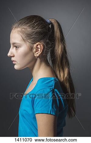 Side view of sad girl standing against gray background View Large Photo Image Stock Image - Side view of sad girl standing against gray background. Fotosearch