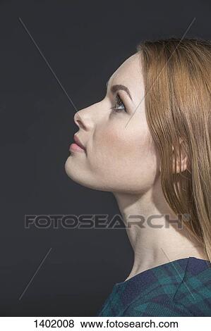 Side view of thoughtful young woman looking up over gray background View Large Photo Image Stock Photo - Side view of thoughtful young woman looking up over gray background. Fotosearch