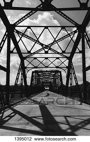 Stock Image - Silhouette bridge against cloudy sky. Fotosearch