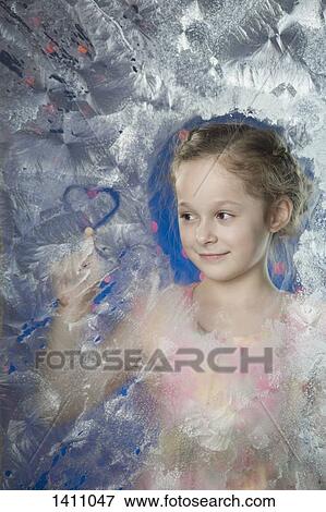 Smiling girl making heart shape on frozen glass View Large Photo Image Stock Photo - Smiling girl making heart shape on frozen glass. Fotosearch