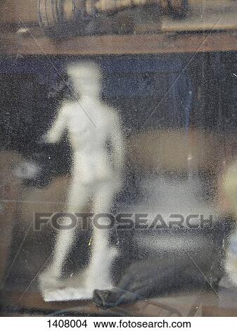 Picture - Statue seen through wet glass window. Fotosearch