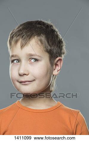 Thoughtful boy looking away against gray background View Large Photo Image Stock Photo - Thoughtful boy looking away against gray background. Fotosearch