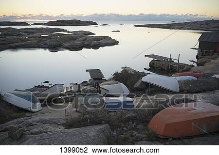 Upside down boats on rocks by lake View Large Photo Image Stock Image - Upside down boats on rocks by lake. Fotosearch