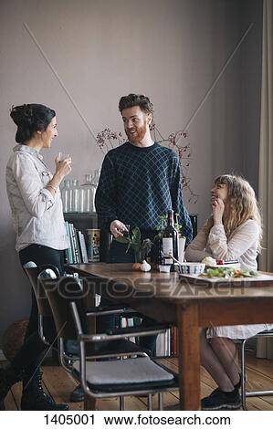 Young man with female friends having breakfast at home View Large Photo Image Stock Image - Young man with female friends having breakfast at home. Fotosearch