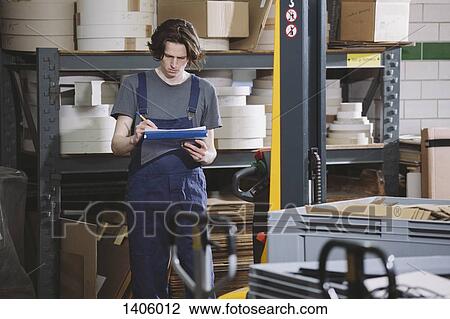 Young manual worker in coveralls writing notes in warehouse View Large Photo Image Stock Image - Young manual worker in coveralls writing notes in warehouse. Fotosearch