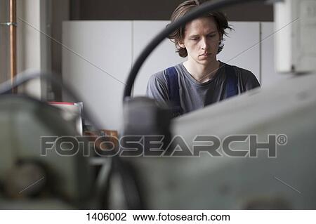 Young manual worker working in factory View Large Photo Image Stock Image - Young manual worker working in factory. Fotosearch