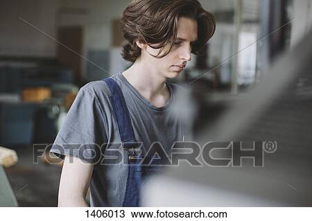 Young manual worker working in factory View Large Photo Image Stock Image - Young manual worker working in factory. Fotosearch