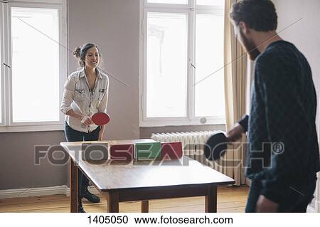 Young woman playing table tennis with man at home View Large Photo Image Stock Image - Young woman playing table tennis with man at home. Fotosearch
