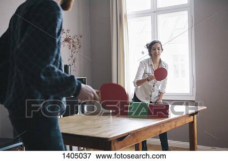 Young woman playing table tennis with man at home View Large Photo Image Stock Photo - Young woman playing table tennis with man at home. Fotosearch