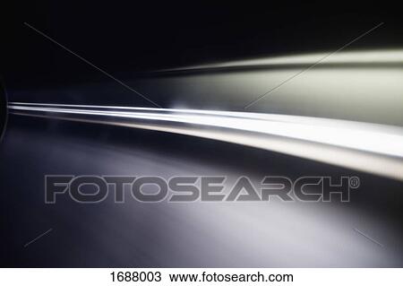 Stock Image - Abstract light trails against black background. Fotosearch