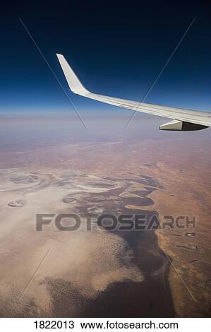 Aerial view airplane wing over landscape View Large Photo Image Stock Image - Aerial view airplane wing over landscape. Fotosearch