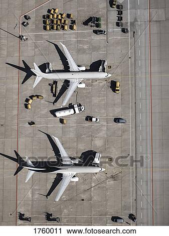 Aerial view commercial airplanes being serviced on tarmac at airport View Large Photo Image Stock Image - Aerial view commercial airplanes being serviced on tarmac at airport. Fotosearch