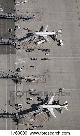 Aerial view commercial airplanes being serviced on tarmac at airport View Large Photo Image Stock Photo - Aerial view commercial airplanes being serviced on tarmac at airport. Fotosearch