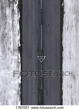 Stock Image - Aerial view helicopter landing triangle on airport tarmac surrounded by snow. Fotosearch