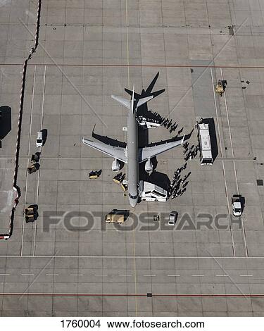 Aerial view of passengers boarding commercial airplane on tarmac at airport View Large Photo Image Picture - Aerial view of passengers boarding commercial airplane on tarmac at airport. Fotosearch
