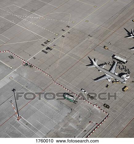 Aerial view of passengers boarding commercial airplane on tarmac at airport View Large Photo Image Stock Image - Aerial view of passengers boarding commercial airplane on tarmac at airport. Fotosearch