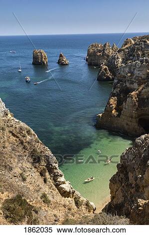 Aerial view tourists boating along ocean cliffs, Lagos, Algarve, Portugal View Large Photo Image Stock Photography - Aerial view tourists boating along ocean cliffs, Lagos, Algarve, Portugal. Fotosearch