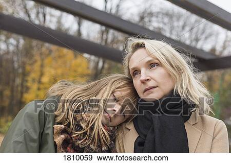 Affectionate, serene mother and daughter in autumn park View Large Photo Image Stock Photo - Affectionate, serene mother and daughter in autumn park. Fotosearch