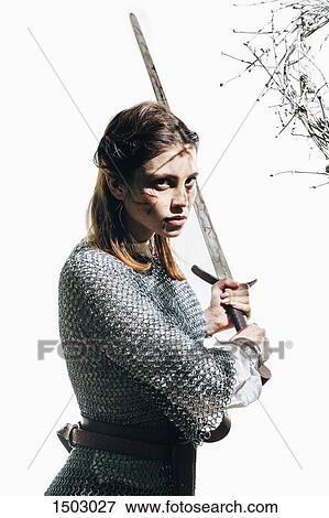 Angry female warrior wearing chain mail holding sword against white background View Large Photo Image Stock Photo - Angry female warrior wearing chain mail holding sword against white background. Fotosearch