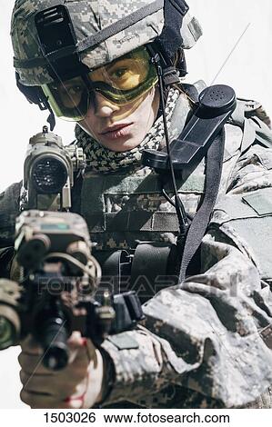Army soldier wearing goggles aiming rifle while standing against white background View Large Photo Image Stock Photograph - Army soldier wearing goggles aiming rifle while standing against white background. Fotosearch