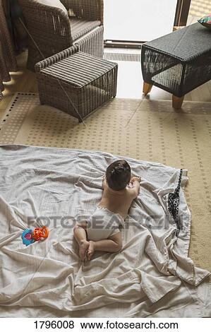 Baby boy laying on blanket in living room View Large Photo Image Stock Photo - Baby boy laying on blanket in living room. Fotosearch
