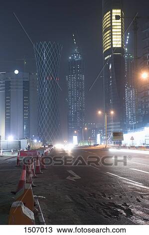 Barricades on illuminated street against buildings in city at night View Large Photo Image Stock Image - Barricades on illuminated street against buildings in city at night. Fotosearch