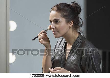 Beautiful woman applying make-up with brush View Large Photo Image Stock Photo - Beautiful woman applying make-up with brush. Fotosearch