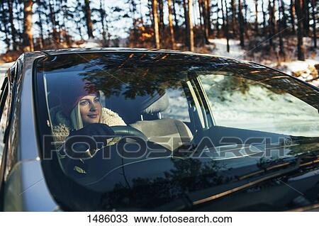 Beautiful woman in warm clothing driving car View Large Photo Image Stock Image - Beautiful woman in warm clothing driving car. Fotosearch