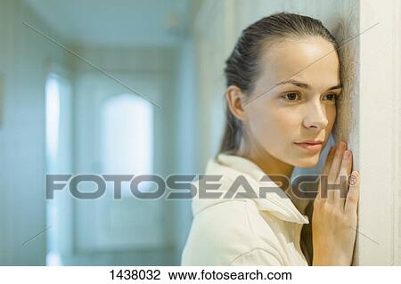 Beautiful woman looking away while leaning on wall at home View Large Photo Image Stock Image - Beautiful woman looking away while leaning on wall at home. Fotosearch