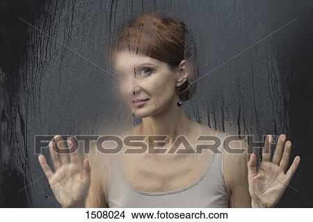 Beautiful woman standing in front on condensed glass against black background View Large Photo Image Picture - Beautiful woman standing in front on condensed glass against black background. Fotosearch