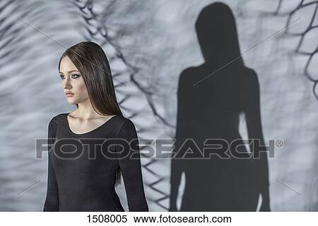 Beautiful woman standing with shadow on gray background View Large Photo Image Stock Photography - Beautiful woman standing with shadow on gray background. Fotosearch