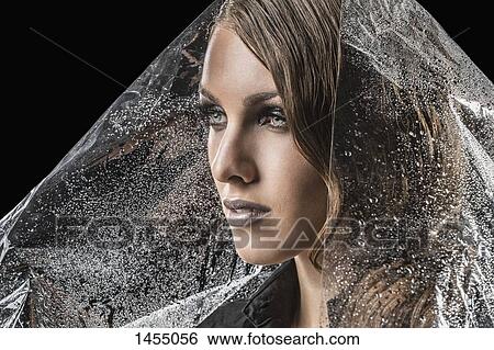 Beautiful woman wrapped in plastic against black background View Large Photo Image Stock Photograph - Beautiful woman wrapped in plastic against black background. Fotosearch