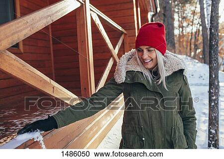 Beautiful young woman removing snow from railing View Large Photo Image Stock Image - Beautiful young woman removing snow from railing. Fotosearch