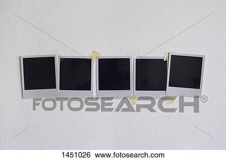 Stock Photograph - Blank instant camera prints stuck on white wall. Fotosearch