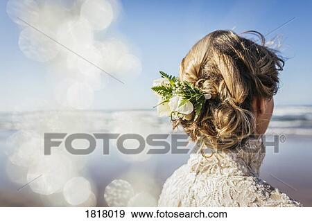 Stock Photo - Blonde bride with flowers in hair on sunny beach. Fotosearch