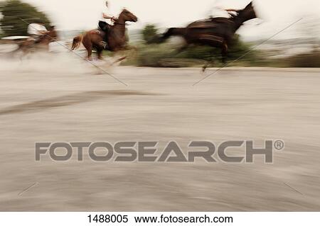 Blurred motion of people riding horses on road, Sedilo, Sardinia, Italy View Large Photo Image Stock Photography - Blurred motion of people riding horses on road, Sedilo, Sardinia, Italy. Fotosearch