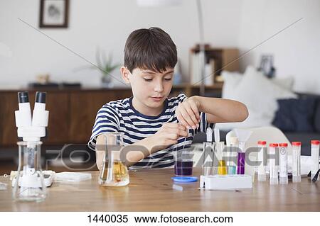 Boy concentrating on school science project at table View Large Photo Image Stock Photography - Boy concentrating on school science project at table. Fotosearch