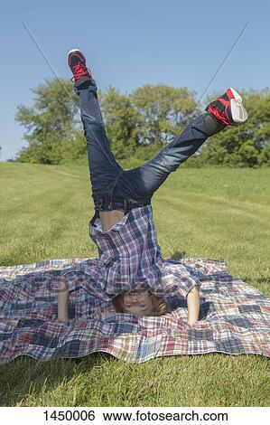 Boy doing headstand at backyard during sunny day View Large Photo Image Stock Photograph - Boy doing headstand at backyard during sunny day. Fotosearch