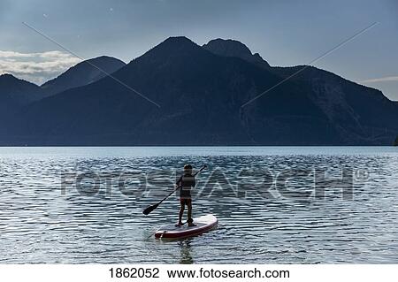 Boy paddleboarding on sunny, idyllic mountain lake, Walchensee, Bavaria, Germany View Large Photo Image Stock Image - Boy paddleboarding on sunny, idyllic mountain lake, Walchensee, Bavaria, Germany. Fotosearch