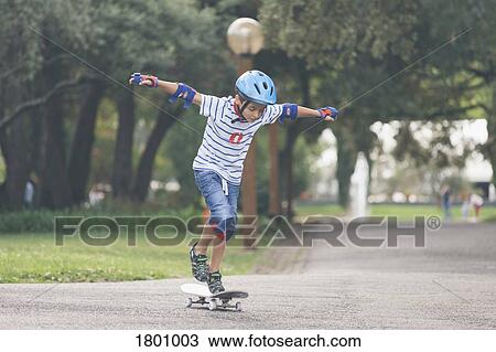 Boy playing, skateboarding in park View Large Photo Image Stock Image - Boy playing, skateboarding in park. Fotosearch