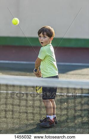 Boy playing tennis on field at court View Large Photo Image Stock Image - Boy playing tennis on field at court. Fotosearch