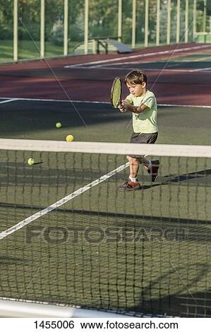 Boy playing tennis on field View Large Photo Image Stock Photograph - Boy playing tennis on field. Fotosearch