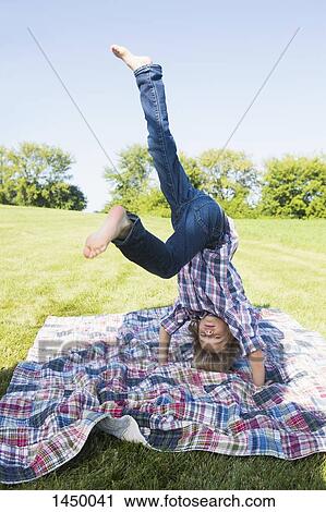 Boy practicing headstand at backyard during sunny day View Large Photo Image Stock Image - Boy practicing headstand at backyard during sunny day. Fotosearch