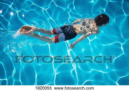 Boy swimming in blue swimming pool View Large Photo Image Stock Photography - Boy swimming in blue swimming pool. Fotosearch